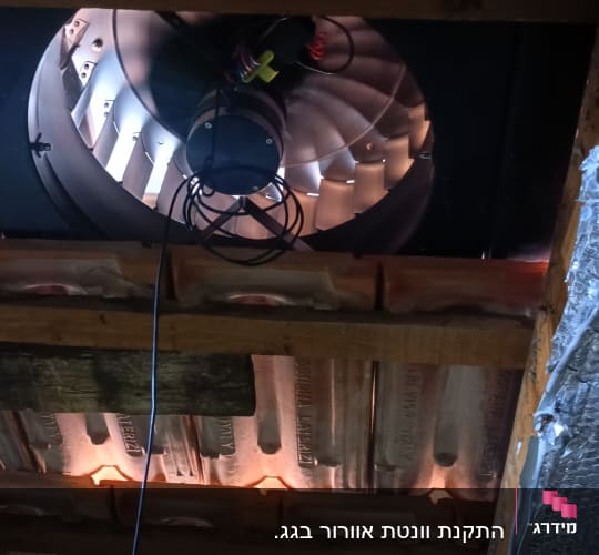 מאוורר מותקן על גג עם רעפים ועץ